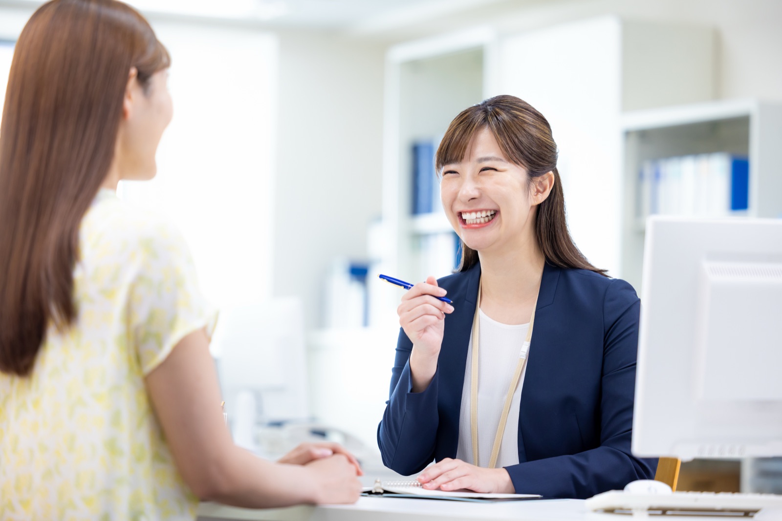 移住相談の窓口で話す相談員と来訪者(全幅帯)