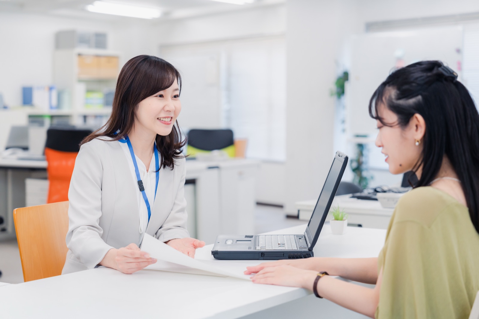 役所の窓口で相談する親子・職員