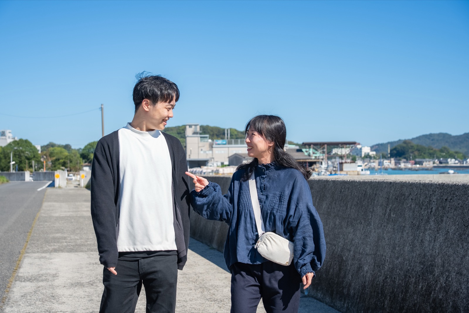 海沿いの道に立つ向井さんご夫婦